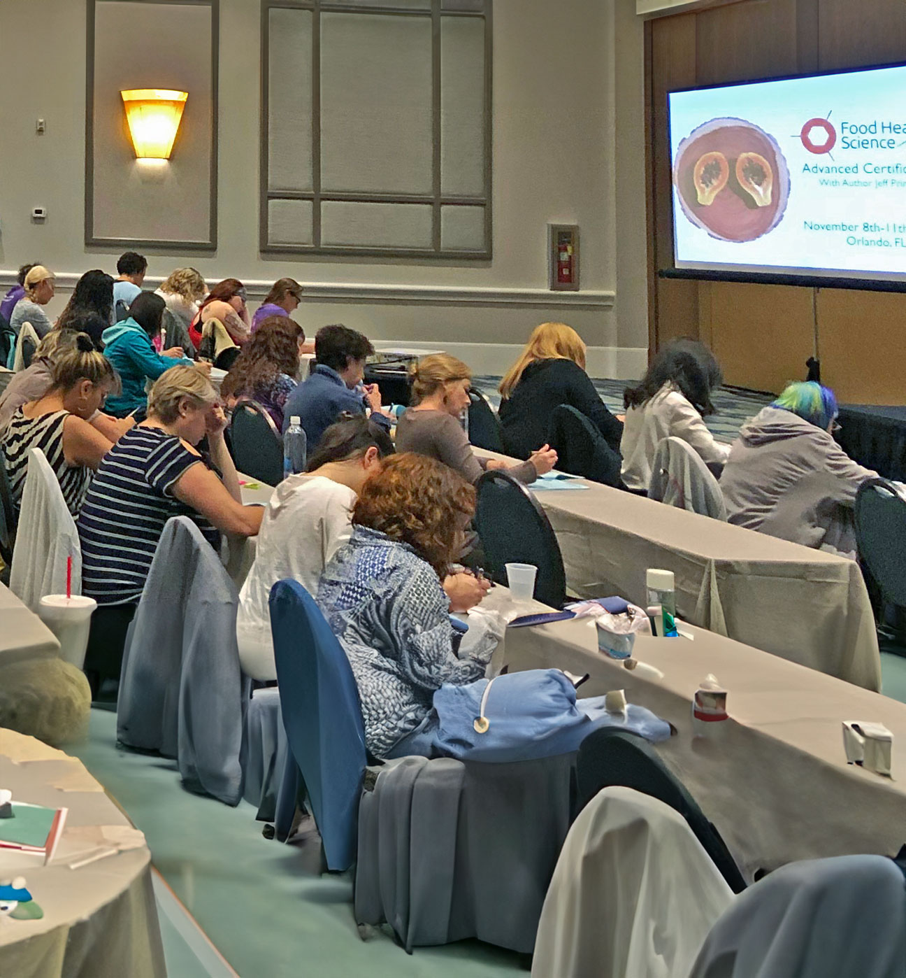 Students taking notes at a Food Healing Science certification course